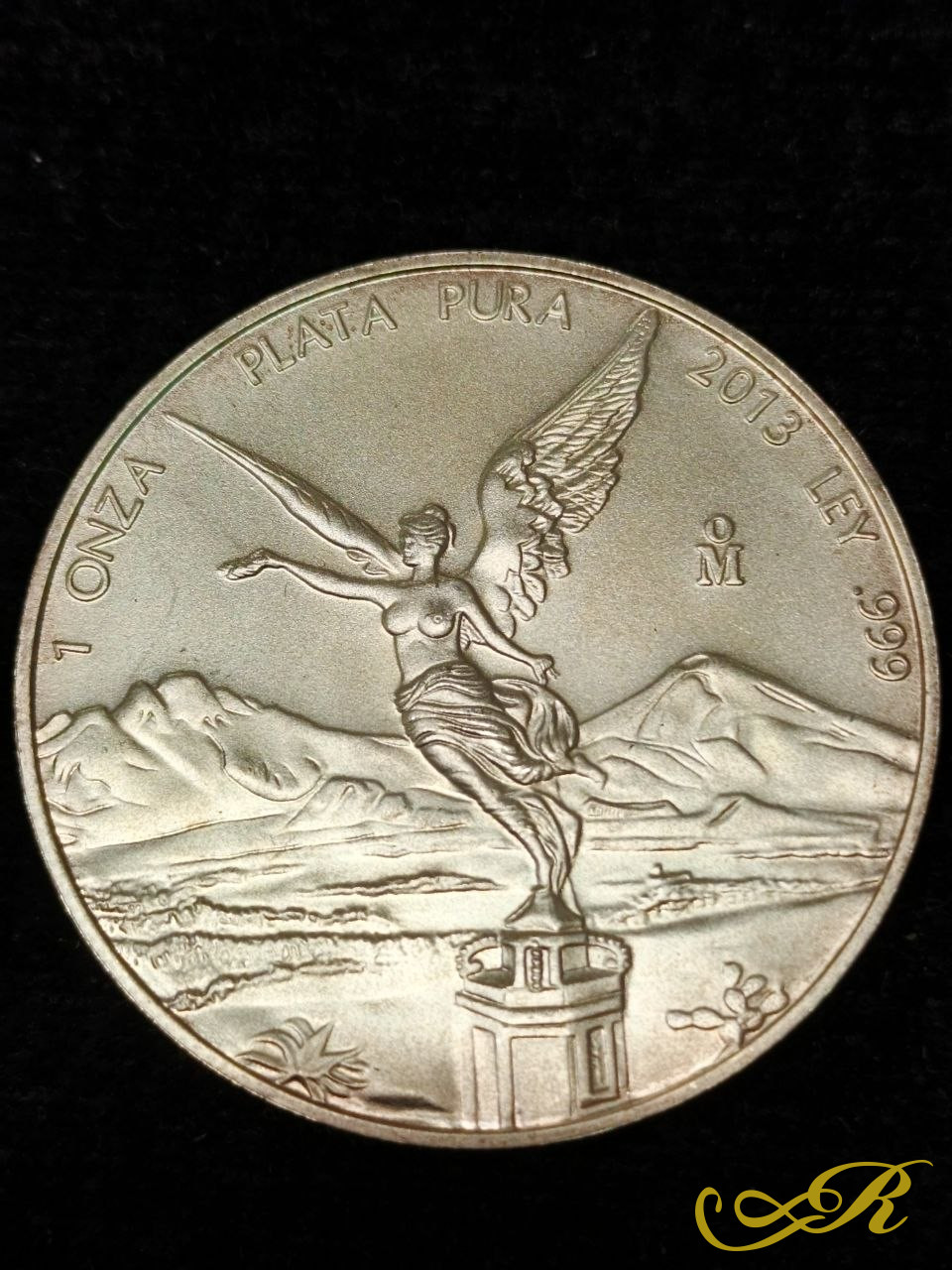  Серебряная инвестиционная монета Мексики «Либертад» (Libertad) номиналом 1 унция. Монета изготовлена из чистого серебра 999 пробы. На реверсе изображена крылатая богиня Виктория (Ангел Независимости) на фоне мексиканских вулканов. Монета была выпущ