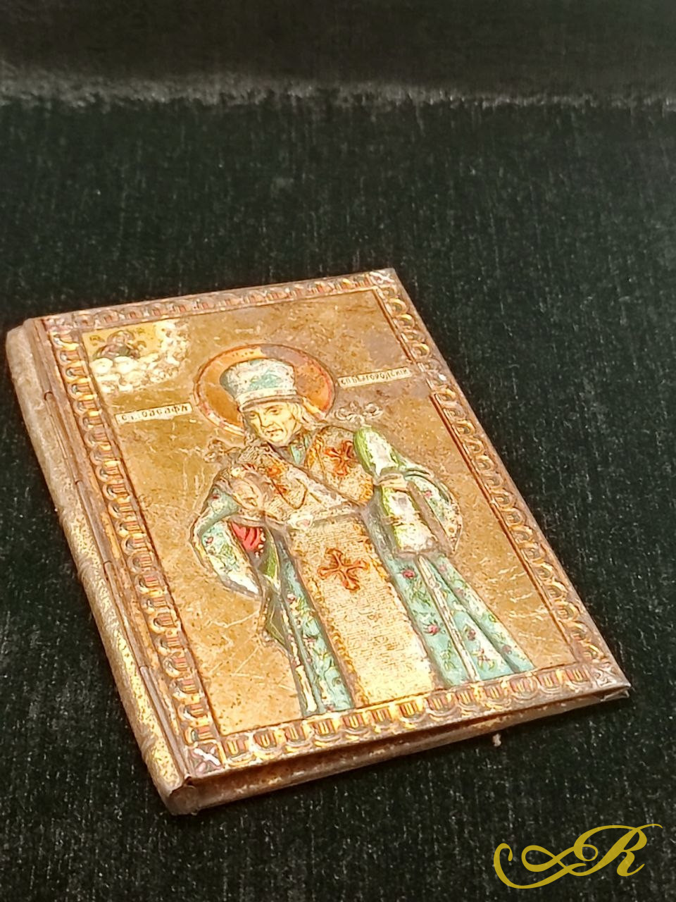 Обложка от старинной православной поминальной книжки (или записной книжки для поминовения) в жесткой прокатной, металлической обложке Жако с хромолитографическим тиснением и изображением святителя, ориентировочно конца XIX — начала XX века (периода Р