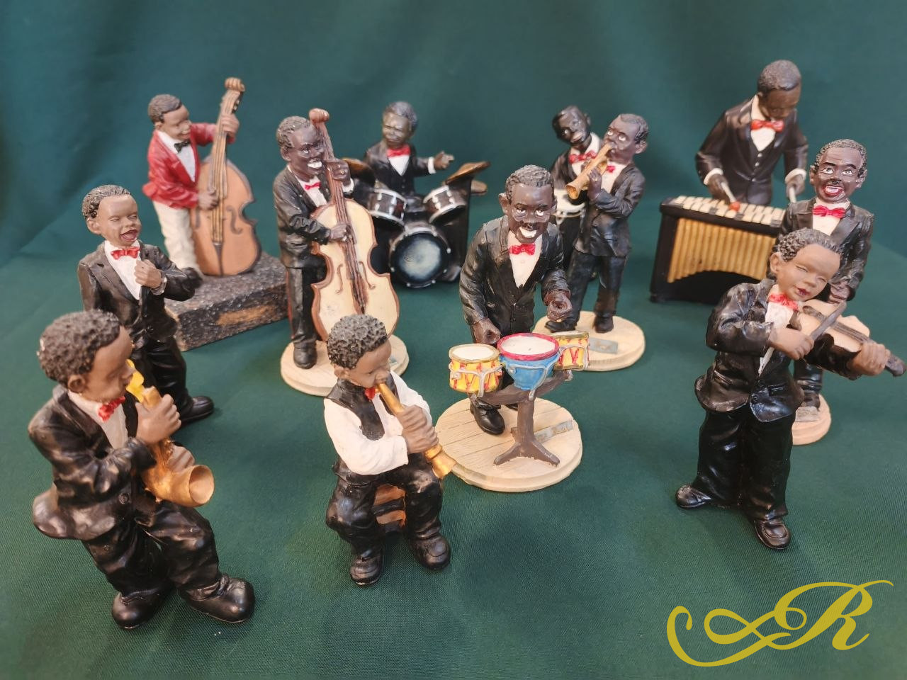  Набор коллекционных фигурок  джазовый оркестр,  «Black Americana Jazz Band»  в стиле «All That Jazz».  Статуэтки выполнены из  композитного материала и изображают афроамериканских музыкантов в черных смокингах с красными бабочками. Всего 12 фигурок.